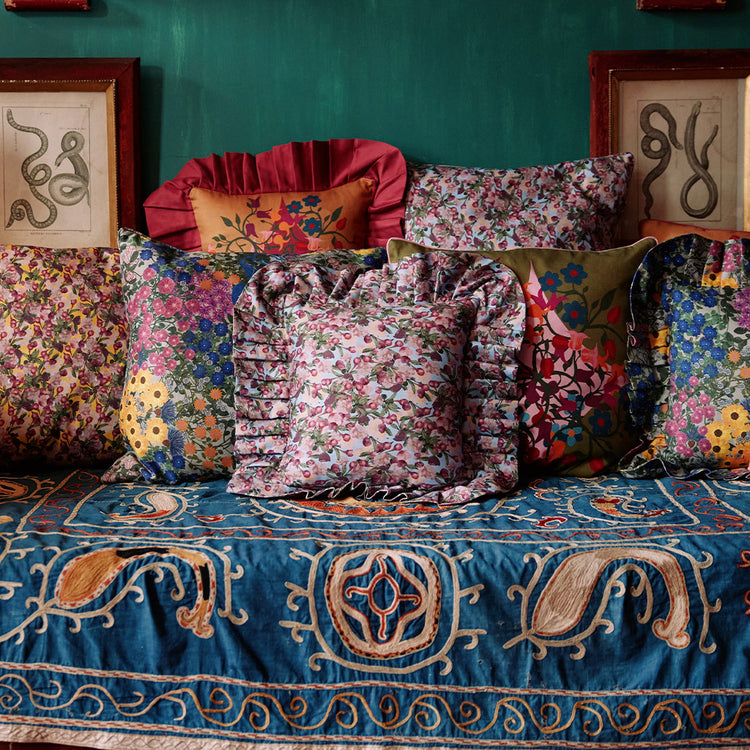 Organic cotton floral pillows on a maximalist day bed
