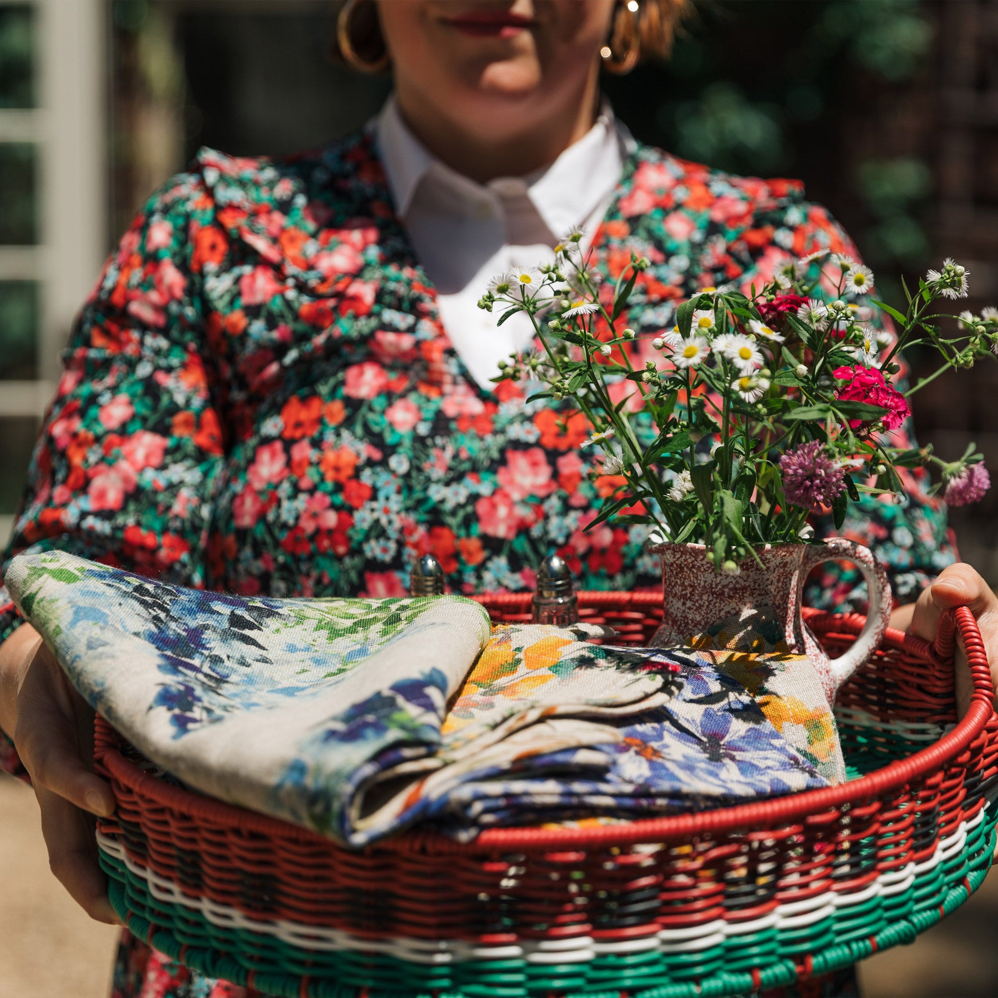 A tray of beautiful linen napkins held by Sophie Williamson Design founder in floral dress.