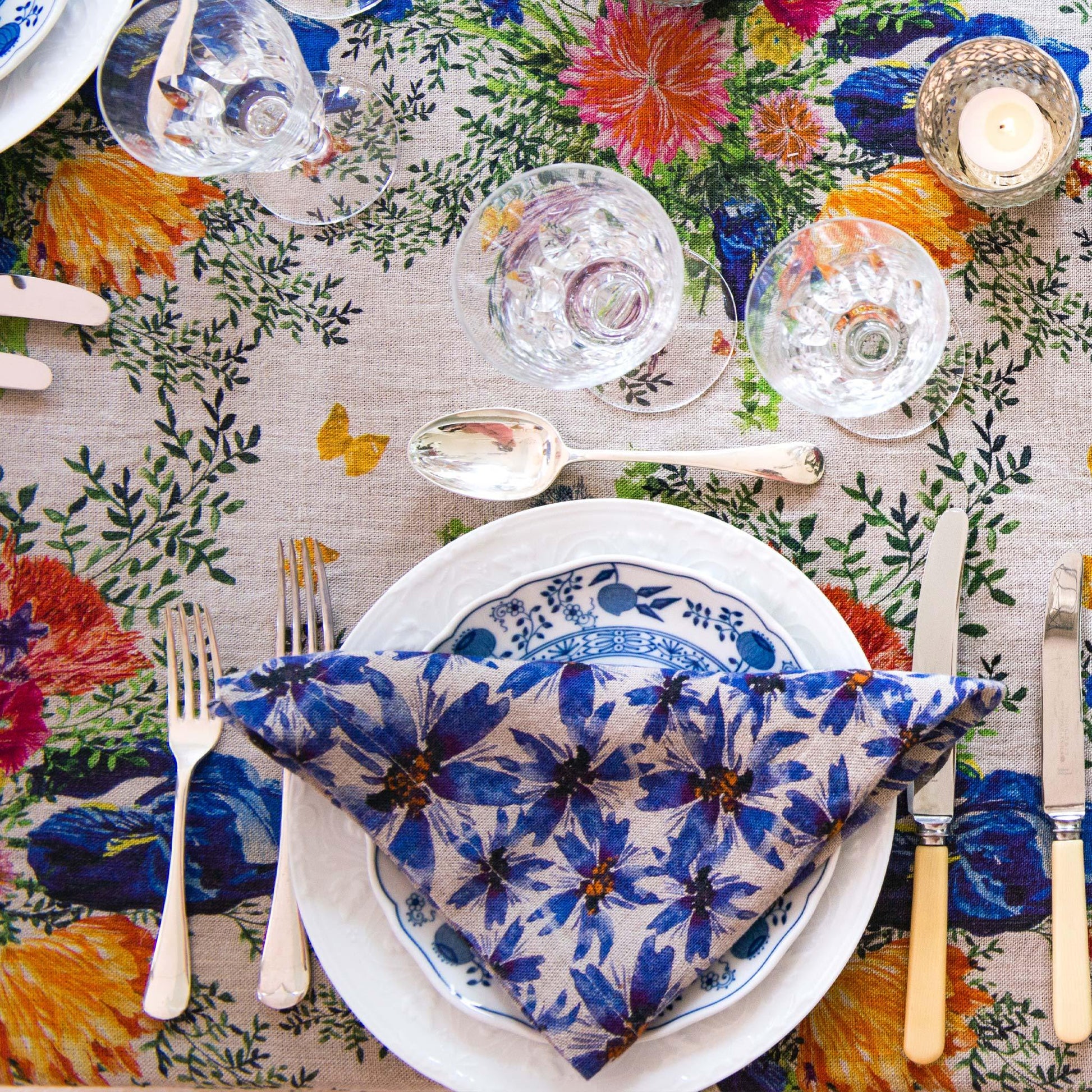 Colorful table setting with blue and white linen napkin.