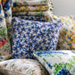 Blue flower print on greige natural linen pillow cover surrounded by other flower print linen pillow covers.