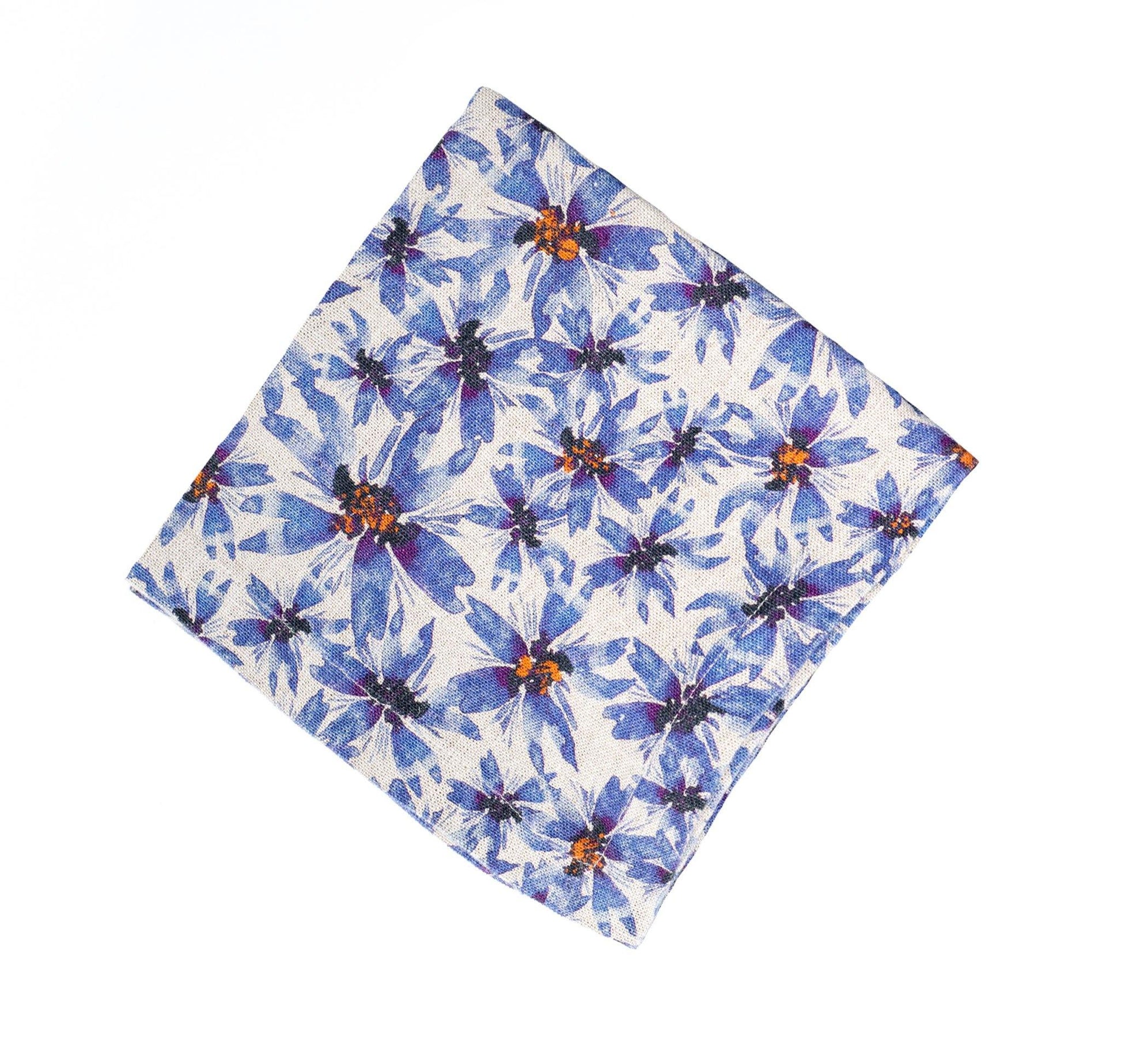 Blue and greige linen napkin with flower print and orange highlight.