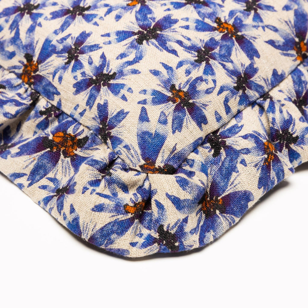 Closeup of corner of organic linen pillow with ruffles printed in whimsical blue florals.
