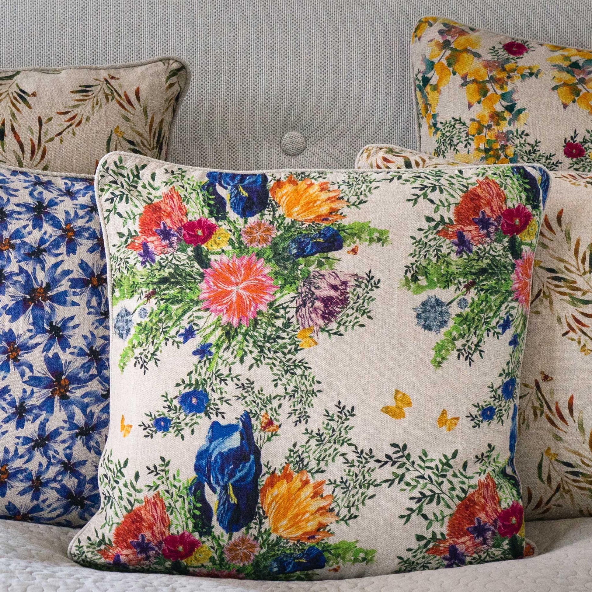 Colorful watercolor illustrated organic linen pillow cover surrounded by other pillow covers.