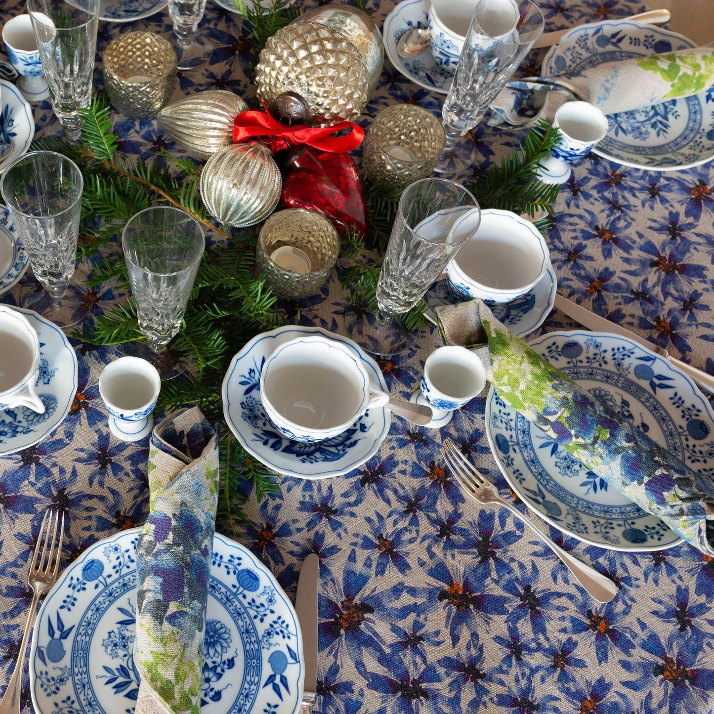 Blue and white table setting with blue floral illustrated table cloth.