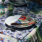 Scene of a table setting with organic linen napkins, sets and tablecloth, printed with colorful floral patterns, by Sophie Williamson Design